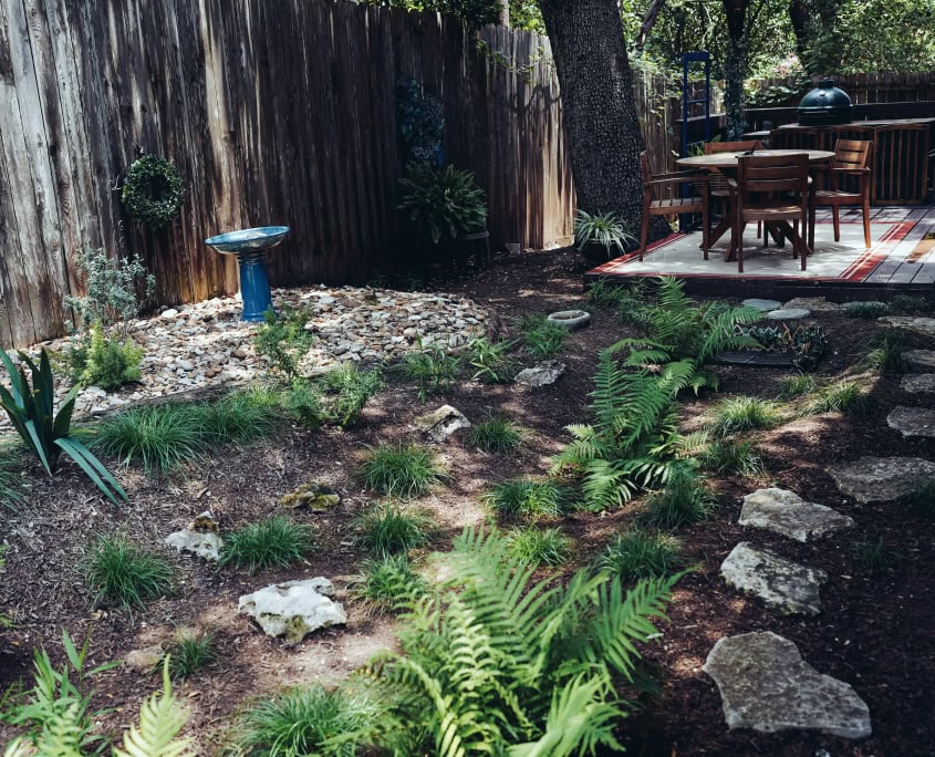 rain garden beside deck with outside table and chairs